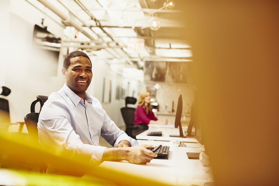 Smiling man sitting behind his desk