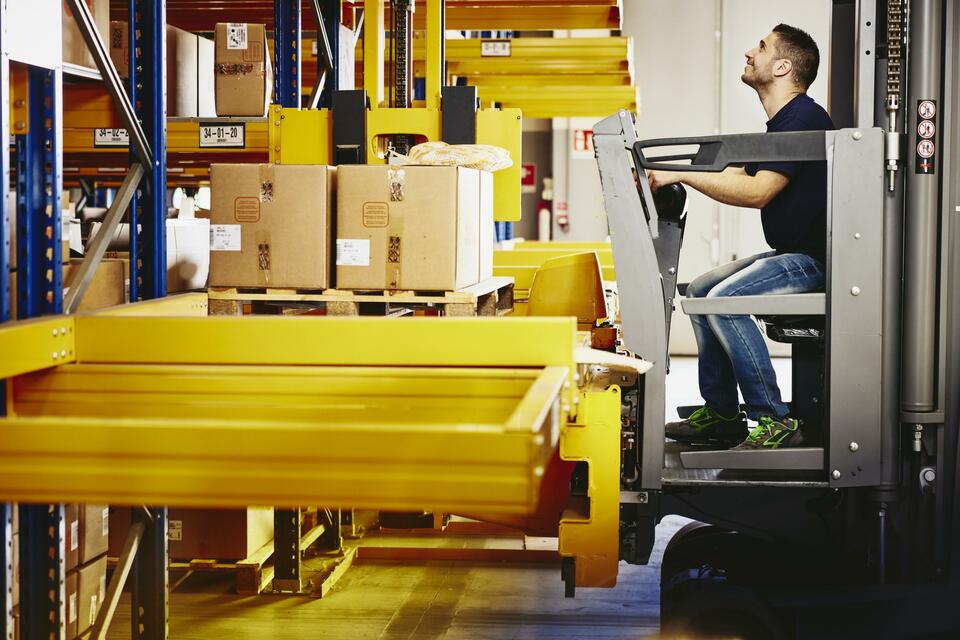 Man operating a forklift with boxes.